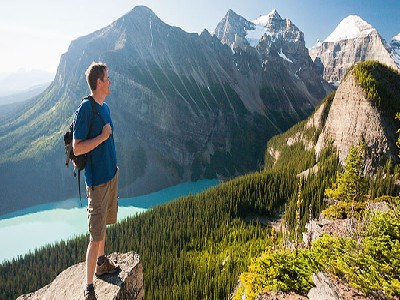 Rocky Mountain Vacations A man standing at the peak of the Rocky Mountains